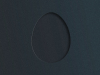 A hole cut out of a piece of black matte card stock, revealing black matte card stock beneath